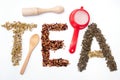 Written tea word with camomile, dog rose and green tea herbs Royalty Free Stock Photo