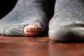 2025 written on a toe and the toe sticks out of a hole in a torn sock on the floor, 2025 Royalty Free Stock Photo