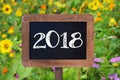 2018 written on a wooden sign, Sunflowers and wild flowers