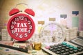 Written word Tax Time on a clock with compass ,coins and Calculator on money banknotes Euro and Dollars,concept of business Royalty Free Stock Photo