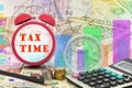 Written word Tax time on clock with compass ,coins and Calcula Royalty Free Stock Photo