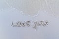 Written words `Love you` on sand of beach. Royalty Free Stock Photo