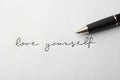 Written words LOVE YOURSELF and pen on white background Royalty Free Stock Photo