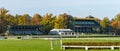 Wroclaw, horse race track with obstacles and high stands for fans, autumn landscape with colorful trees on a sunny day