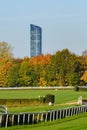 Wroclaw, horse racing track with obstacles, autumn landscape with colorful trees on a sunny day. The modern Sky Tower building