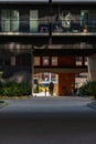 Dark facade of modern block of flats with glass balconies and small tunnel with riding cyclists