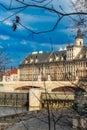 Facade of beautiful building of Wroclaw University next to Odra river seen from behind sticks of