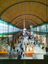 First floor balcony view to interior of main railway station building full of people and open