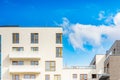 Modern facades of blocks of flats in new estate with wooden window frames and decorations on