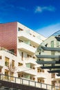 Modern facades of blocks of flats in new estate with wooden window frames and decorations on