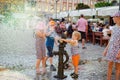 Wroclaw, Poland. August 15, 2017. Children playing with hand water pump with bronze gnome or dwarf sculpture. Summer fun