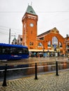 Facade of market hall with riding tram in front of at cloudy rainy day