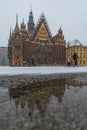Facade of town hall at Market square full of white fresh snow at winter reflected in small