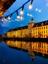 Facade of University of Wroclaw building reflecting in Odra river at afternoon with christmas