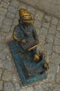 WROCLAW, POLAND: Dwarf is sitting and reading a book, famous bronze miniature gnome with hat sculpture