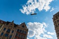 Big airship with Goodyear logo flying over market square at sunny cloudy day