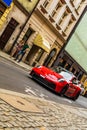 A red sports Porsche driving through the city streets