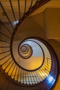 Beautiful renovated old wooden spiral staircase inside old and high tenement building with glowing Royalty Free Stock Photo