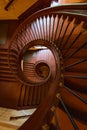 Beautiful renovated old wooden spiral staircase inside old and high tenement building with glowing