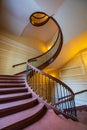 Beautiful renovated old wooden spiral staircase inside old and high tenement building with glowing Royalty Free Stock Photo
