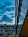 Facade of modern block of flat full of modern apartments at cloudy afternoon reflected in facade