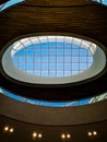 Looking up to ceiling and round skylight of shopping mall