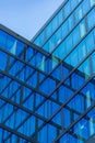 Upward view of a tall and modern office building full of glass windows reflecting the walls, Royalty Free Stock Photo