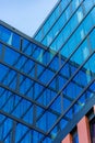 Upward view of a tall and modern office building full of glass windows reflecting the walls, Royalty Free Stock Photo