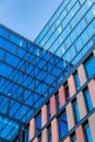 Upward view of a tall and modern office building full of glass windows reflecting the walls, Royalty Free Stock Photo