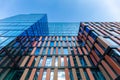 Upward view of a tall and modern office building full of glass windows reflecting the walls, Royalty Free Stock Photo