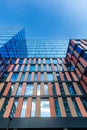 Upward view of a tall and modern office building full of glass windows reflecting the walls, Royalty Free Stock Photo