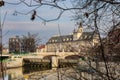 Pomorski bridge in front of facade of Wroclaw University building seen from behind small tree