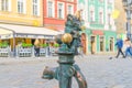 Wroclaw, Poland, May 7, 2019: Dwarf is sitting on street water tap on Rynek Market Square Royalty Free Stock Photo