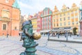 Wroclaw, Poland, May 7, 2019: Dwarf is sitting on street water tap on Rynek Market Square Royalty Free Stock Photo