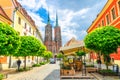 Wroclaw, Poland, May 7, 2019: Street with cobblestone road with green trees, colorful buildings Royalty Free Stock Photo