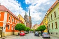 Wroclaw, Poland, May 7, 2019: Street with cobblestone road, green trees, colorful buildings Royalty Free Stock Photo