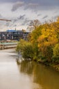 Beautiful and colorful cloudy cityscape of high trees and bushes and modern buildings at other