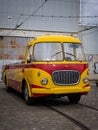 An empty, vintage cabrio Skoda bus in front of the depot.