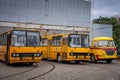 Three empty vintage Ikarus and Skoda buses in front of the depot.