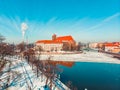 Snowy landscape with ever green trees on the side of a River - Smoke from Chimneys