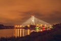 Wroclaw, Redzinski bridge over Odra river, illuminated structure at night with low hanging clouds over the city. Royalty Free Stock Photo