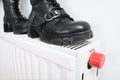 Wrong drying of footwear, a pair of dirty leather winter shoes on a hot central heating radiator