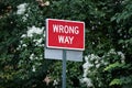 Wrong way traffic sign indicating that you can not enter on that street. Green trees background. Royalty Free Stock Photo