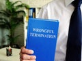 Wrongful termination. The employee holds book in his hands.