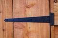 Wrought iron black t-hinge on wooden shed door. Royalty Free Stock Photo