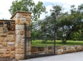 Wrought iron entrance gate set in sandstone fence Royalty Free Stock Photo