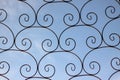 Wrought iron fence on a blue background.