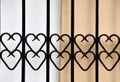 Wrought-iron railing with hearts in front of a wall Royalty Free Stock Photo