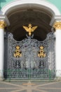 Wrought iron grille gate with the imperial double-headed eagle and the monogram on the entrance of the Winter Palace. St.