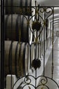 Through the wrought-iron metal gate you can see the wine cellar with old oak barrels lying in a row Royalty Free Stock Photo